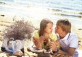 Happy young couple enjoying picnic on the beach and have good ti Royalty Free Stock Photo