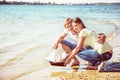 Happy young couple enjoying picnic on the beach and have good ti Royalty Free Stock Photo