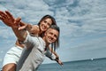 Happy young couple enjoying a solitary beach back riding