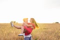 Happy young couple enjoying in the wheat field, summer season. Sunset light, flare light, copy space Royalty Free Stock Photo