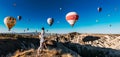 A happy young couple enjoys balloons during sunrise in Cappadocia, Turkey, panorama. Travel to the tourist places of Turkey