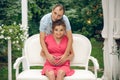 Happy young couple expecting baby, pregnant woman with husband touching belly, sitting on white sofa Royalty Free Stock Photo