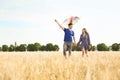 Happy young couple flying kite in a field Royalty Free Stock Photo