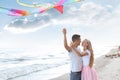 Happy young couple flying kite near sea Royalty Free Stock Photo