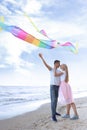 Happy young couple flying kite near sea Royalty Free Stock Photo