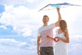 Happy young couple flying kite outdoors Royalty Free Stock Photo