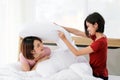 Happy young couple friend beautiful asia women having a pillow fight in their bedroom