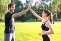 Happy young couple giving high five while standing in park Royalty Free Stock Photo