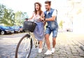 Happy young couple going for a bike ride on a summer day in the city.They are having fun together. Royalty Free Stock Photo