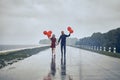 Happy young couple guy and girl are walking in the rain with bubble balls. hello concept autumn, good mood