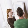 Happy Young Couple Hanging Frame