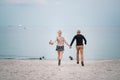 Happy young couple have fun on the beach, holding hands. Royalty Free Stock Photo