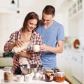 Happy young couple have fun in modern wooden kitchen indoor while preparing fresh food Royalty Free Stock Photo