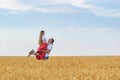 Happy young couple have fun in wheat field on sunny summer day. A man holds beloved in his hands Royalty Free Stock Photo