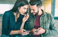 Happy young couple having fun with mobile smart phone at urban place - Friendship concept with best friends connecting and sharing Royalty Free Stock Photo