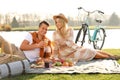 Happy young couple having picnic near lake Royalty Free Stock Photo