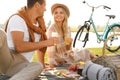 Happy young couple having picnic near lake Royalty Free Stock Photo