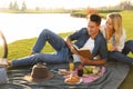 Happy young couple having picnic near lake Royalty Free Stock Photo