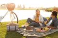 Happy young couple having picnic near lake Royalty Free Stock Photo