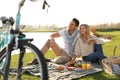 Happy young couple having picnic near lake Royalty Free Stock Photo