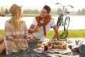 Happy young couple having picnic near lake Royalty Free Stock Photo