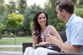 Happy young couple having red wine on chairs in park Royalty Free Stock Photo