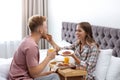 Happy young couple having romantic breakfast on bed Royalty Free Stock Photo