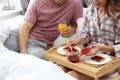 Happy young couple having romantic breakfast in bed at home Royalty Free Stock Photo