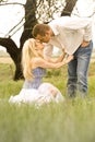 Happy young couple having a romantic kiss outdoors in green field Royalty Free Stock Photo