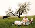 Happy young couple having a romantic picnic outdoors in green field Royalty Free Stock Photo