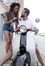 Happy young couple having summer trip on a scooter Royalty Free Stock Photo