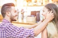 Happy young couple having tender moments and drinking cocktails in lounge bar - Millennial lovers having fun in summer party -