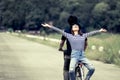 Happy young couple of hipsters riding a bicycle together