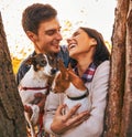 Happy young couple holding dogs in park Royalty Free Stock Photo