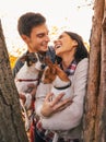 Happy young couple holding dogs in park and smiling Royalty Free Stock Photo