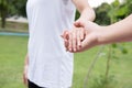 happy young couple holding hands in garden. Boyfriend and girlfriend walking in public park. Love, romance and relationship Royalty Free Stock Photo