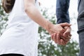 happy young couple holding hands in garden. Boyfriend and girlfriend walking in public park. Love, romance and relationship Royalty Free Stock Photo