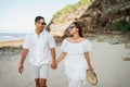 Happy young couple holding hands and laughing on the beach Royalty Free Stock Photo