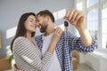 Happy young couple holding a key in their hands standing in a new apartment on moving day. Royalty Free Stock Photo