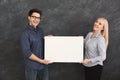 Young couple holding blank white banner