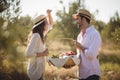 Happy young couple holding wicket basket at olive farm