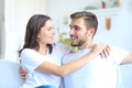 Happy young couple hugging and looking at each other at home interior. Royalty Free Stock Photo