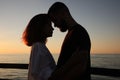 Happy young couple hugging on sea embankment at sunset Royalty Free Stock Photo