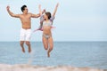 Happy young couple jumping  on sea beach. Space for text Royalty Free Stock Photo