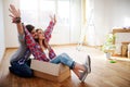 Happy young couple just moved new home unpacking boxes; having fun Royalty Free Stock Photo