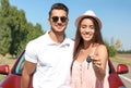 Happy young couple with key standing near new car Royalty Free Stock Photo