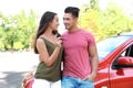 Happy young couple with key standing near new car Royalty Free Stock Photo