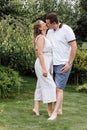 Happy young couple kissing and hugging outdoors on summer day. woman and man in love in the park Royalty Free Stock Photo