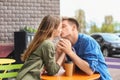 Happy young couple kissing in street cafe Royalty Free Stock Photo