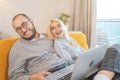 Happy young couple laughing and having fun at home, making online purchases in internet stores Royalty Free Stock Photo